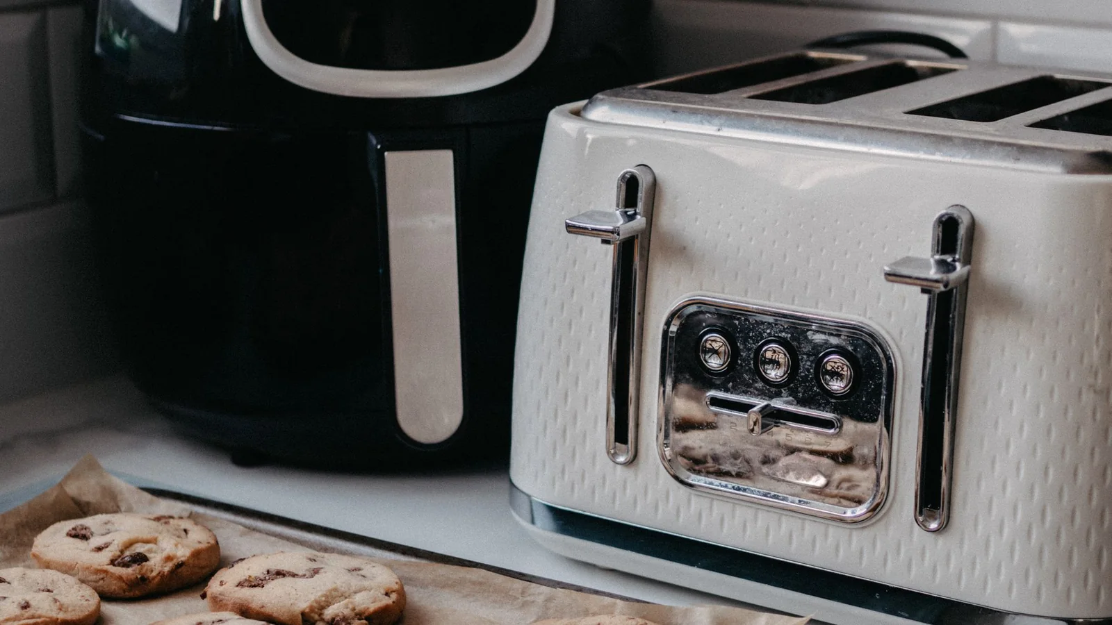 Mutfak tezgahında air fryer, ekmek kızartma makinesi ve kurabiyeler