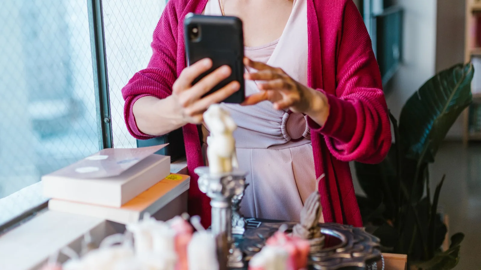 Masadaki ürünleri akıllı telefonla fotoğraflayan kadın